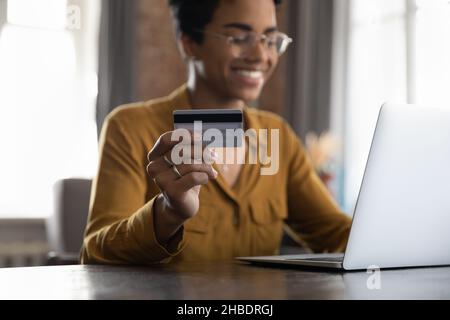 Glückliche afroamerikanische Frau, die im Internet-Shop einkauft. Stockfoto