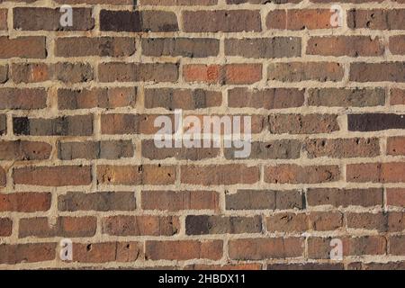 Ein voller Rahmen einer typischen braunen Ziegelwand an einem schönen Herbsttag. Stockfoto