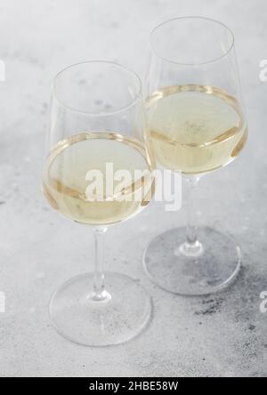 Zwei Gläser weißen hausgemachten Sommer erfrischenden Wein auf hellem Stein Hintergrund. Stockfoto