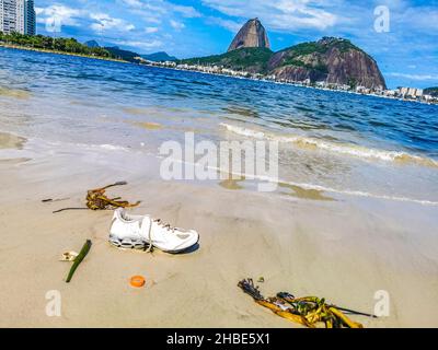 Schuh strandete aufgespülten Müll und Müllverschmutzung auf dem Botafogo Beach Sand in Rio de Janeiro Brasilien. Stockfoto