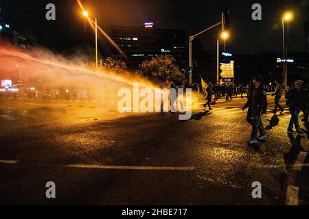 Raánana, Israel. 18th Dez 2021. Demonstranten gegen die Beschränkungen von Corona und Kinderimpfstoffe in Israel hatten nach der jüngsten Strenge der Beschränkungen den nahe gelegenen Premierminister Naftali Benet in Raanana demonstriert. Die Polizei hatte die Demonstranten blockiert und sie daran gehindert, für einen marsch auszuziehen - mit Kavaliers, die die Menge, die ein Polizeifahrzeug schüttelte, peitschten. Schließlich hatte der Protest es geschafft, eine nahe gelegene Kreuzung auf einer israelischen Hauptstraße zu blockieren - während die Polizei mit Wasserwerfern die Kontrolle über die Kreuzung zurückgewann.Raánana, Israel. 18th. Dezember 2021.(Matan Golan/Alamy Live Ne Stockfoto