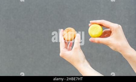 Frau Hände halten organische Seife oder festes Shampoo ohne Verpackung auf grauem Hintergrund. Gesunder Lebensstil, Schönheit, Hautpflege, Zero Waste Konzept. Co Stockfoto