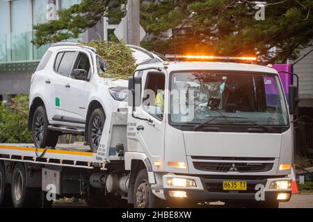 Stürme in Narrabeen Dezember 2021, gefallene Bäume zerquetschen das Dach eines Autos, das von einem Abschleppwagen wegtransportiert wird, Sydney, NSW, Australien Stockfoto