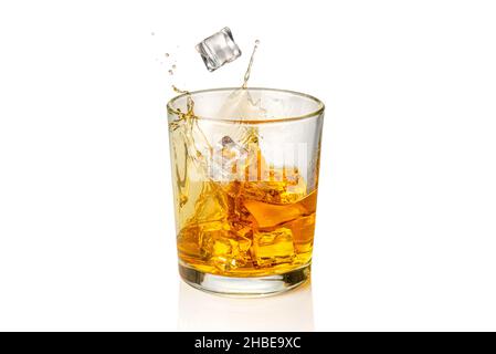 Glas Whiskey, Whiskey oder Bourbon mit fallenden Eiswürfeln mit Spritzer, isoliert auf Weiß Stockfoto