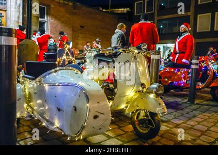 Kiel, Deutschland. 19th Dez 2021. Weihnachtlich geschmückte Vespa-Roller stehen nach einer Tour in der Kieler Innenstadt. Der 'Vespa Club Kiel' existiert seit 70 Jahren und ist damit einer der ältesten in Deutschland. Quelle: Frank Molter/dpa/Alamy Live News Stockfoto