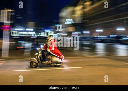 Kiel, Deutschland. 19th Dez 2021. Mitglieder des 'Vespa Club Kiel' verkleidet, als Weihnachtsmänner mit ihren Vespas durch die Kieler Innenstadt fahren. Der Club besteht seit 70 Jahren und ist damit einer der ältesten in Deutschland. Quelle: Frank Molter/dpa/Alamy Live News Stockfoto