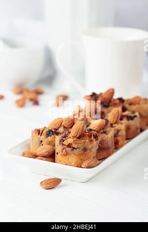 Kleine Kuchen mit Mandeln, Rosinen und Honig auf einem weißen Tisch. Stockfoto