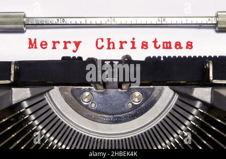 Auf der Vintage-Schreibmaschine wird „Frohe Weihnachten“ geschrieben. Weihnachtszeit. Stockfoto