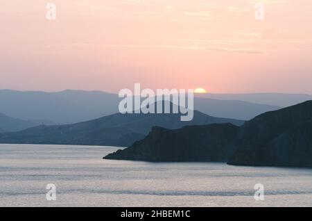 Sommerlandschaft am Meer. Blick auf die Berge und die untergehende Sonne. Krim, Ukraine, Europa. Farbtonung Stockfoto