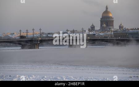 Winterpanorama von St. Petersburg an frostigen Tagen, Isaac Kathedrale und Blagoveshenskiy Brücke im Hintergrund, Dampf über gefrorenen Fluss Neva Stockfoto