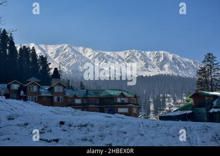 Gulmarg, Indien. 19th Dez 2021. Die Besucher wandern an einem kalten Wintertag in Gulmarg, etwa 55kms von Srinagar entfernt, durch einen schneebedeckten Hügel.die zitternden kalten Bedingungen im Kashmir-Tal setzten sich unvermindert fort, als die Sommerhauptstadt Srinagar am Sonntag in der zweiten Nacht in Folge minus 6,0 Grad Celsius verzeichnete. Wettermann hat von Dezember 22 bis 25 leichten bis mäßigen Schneefall vorhergesagt. Kredit: SOPA Images Limited/Alamy Live Nachrichten Stockfoto