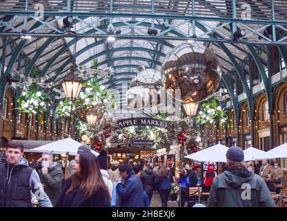 Shopper and Christmas Decorations at Covent Garden Market, London, UK 19. Dezember 2021. Stockfoto