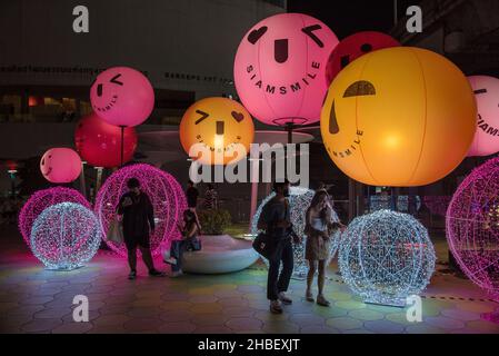 Bangkok, Thailand. 19th Dez 2021. Vor der Weihnachts- und Neujahrszeit vor dem MBK Center in Bangkok laufen die Menschen an beleuchteten Weihnachtsdekorationen vorbei. Kredit: SOPA Images Limited/Alamy Live Nachrichten Stockfoto