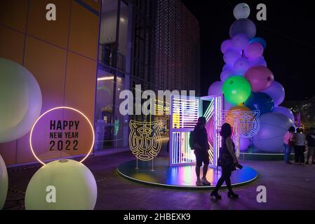 Bangkok, Thailand. 19th Dez 2021. Vor der Weihnachts- und Neujahrszeit vor dem MBK Center in Bangkok laufen die Menschen an beleuchteten Weihnachtsdekorationen vorbei. Kredit: SOPA Images Limited/Alamy Live Nachrichten Stockfoto