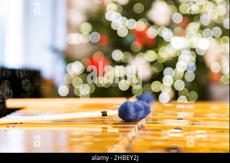 Vibraphon-Sticks liegen auf diesem Percussion-Instrument. Im Hintergrund verschwommene, unscharfe Lichter des Weihnachtsbaums. Stockfoto
