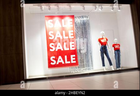 Schaufenster mit Rabatt- und Verkaufsschild und Schaufensterpuppen Stockfoto