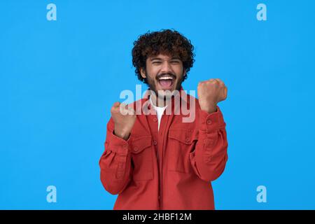 Aufgeregt glücklich jungen indischen Mann Gewinner zeigt ja isoliert auf blauem Hintergrund. Stockfoto