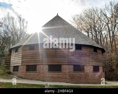 Die Sonne steht hinter einer runden Scheune in Virginia Stockfoto