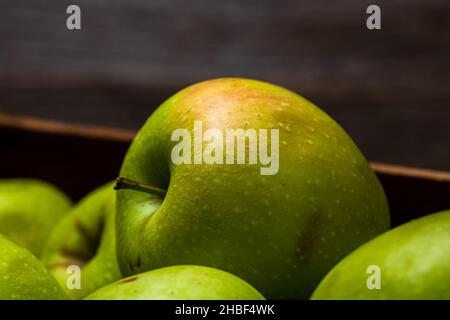 Eine Nahaufnahme von reifen grünen Äpfeln in einem hölzernen Kiste Stockfoto