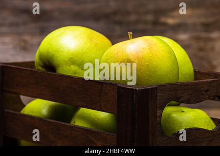 Eine Nahaufnahme von reifen grünen Äpfeln in einem hölzernen Kiste Stockfoto