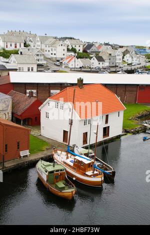 Traditionelle Holzgebäude und Boote entlang der Uferpromenade und des Yachthafens. Smedasundet Gebiet und Fluss im Zentrum der Stadt, Haugesund, Norwegen. Stockfoto