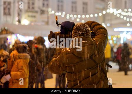 Presse- und Medienfotograf im Dienst in öffentlichen Nachrichten in der weihnachtszeit. Stockfoto