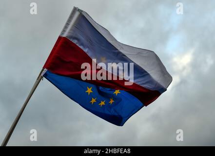 Krakau, Polen. 19th Dez 2021. Die polnische Flagge vor dem Hintergrund der EU-Flagge während der Demonstration. Protest zur Verteidigung freier Medien nach der Annahme des sogenannten Lex-TVN im Sejm im polnischen Parlament, der den Verkauf von TVN durch den amerikanischen Eigentümer erzwingt. Kredit: SOPA Images Limited/Alamy Live Nachrichten Stockfoto