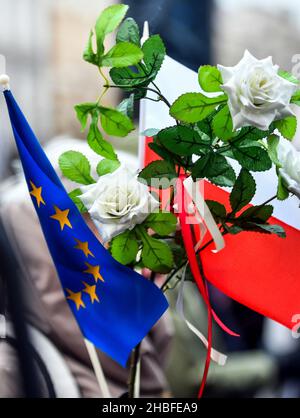 Krakau, Polen. 19th Dez 2021. Weiße Rosen vor dem Hintergrund der polnischen und EU-Flaggen, die während der Demonstration gesehen wurden. Protest zur Verteidigung freier Medien nach der Annahme des sogenannten Lex-TVN im Sejm im polnischen Parlament, der den Verkauf von TVN durch den amerikanischen Eigentümer erzwingt. Kredit: SOPA Images Limited/Alamy Live Nachrichten Stockfoto