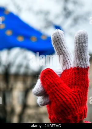 Krakau, Polen. 19th Dez 2021. Hand in einem rot-weißen Handschuh Gesten während der Demonstration. Protest zur Verteidigung freier Medien nach der Annahme des sogenannten Lex-TVN im Sejm im polnischen Parlament, der den Verkauf von TVN durch den amerikanischen Eigentümer erzwingt. Kredit: SOPA Images Limited/Alamy Live Nachrichten Stockfoto