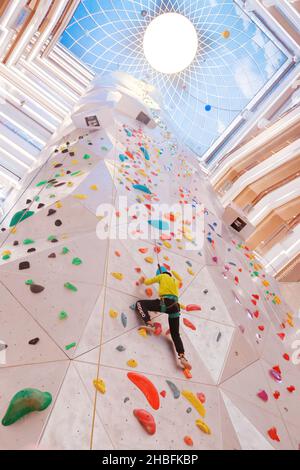 SHANGHAI, CHINA - 19. DEZEMBER 2021 - Winter-Fitness-Enthusiasten erleben die höchste Indoor-Kletterwand der Welt in der New World Mall, a com Stockfoto