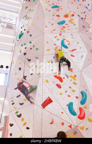 SHANGHAI, CHINA - 19. DEZEMBER 2021 - Winter-Fitness-Enthusiasten erleben die höchste Indoor-Kletterwand der Welt in der New World Mall, a com Stockfoto