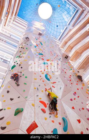 SHANGHAI, CHINA - 19. DEZEMBER 2021 - Winter-Fitness-Enthusiasten erleben die höchste Indoor-Kletterwand der Welt in der New World Mall, a com Stockfoto