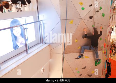 SHANGHAI, CHINA - 19. DEZEMBER 2021 - Winter-Fitness-Enthusiasten erleben die höchste Indoor-Kletterwand der Welt in der New World Mall, a com Stockfoto