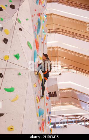 SHANGHAI, CHINA - 19. DEZEMBER 2021 - Winter-Fitness-Enthusiasten erleben die höchste Indoor-Kletterwand der Welt in der New World Mall, a com Stockfoto