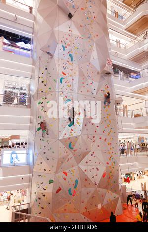 SHANGHAI, CHINA - 19. DEZEMBER 2021 - Winter-Fitness-Enthusiasten erleben die höchste Indoor-Kletterwand der Welt in der New World Mall, a com Stockfoto