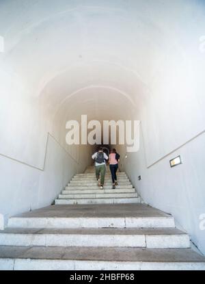 Lovcen Nationalpark. Schwach beleuchtete steile, weiße Steintreppen, die durch einen langen schmalen Tunnel im Berg hinauf zum Mausoleum von Petar II Petrovic führen. Stockfoto