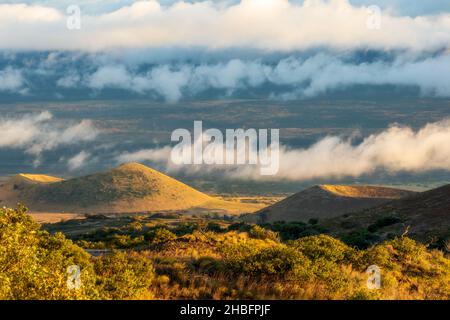 Von der Straße, die zu den Observatorien auf der Mauna Kea und der Onizuka-Besucherstation führt, hat man einen malerischen Blick auf den Sonnenuntergang. Hawaii Stockfoto