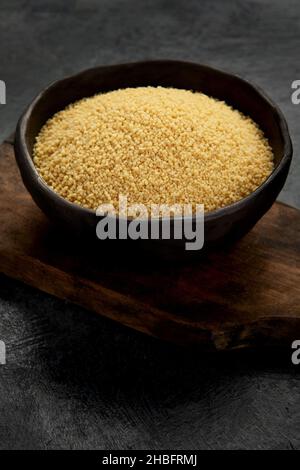 Couscous auf dunklem Hintergrund. Traditionelles Vollkorn. Stockfoto