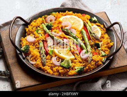 Vegane Paella auf grauem Hintergrund. Mediterrane Ernährung. Gesundes Lebensmittelkonzept. Stockfoto