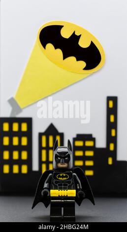 Bologna - Italien - 12. Dezember 2021: LEGO Batman Miniatur gegen Gotham City Hintergrund. Batsignal von den Dächern. Stockfoto