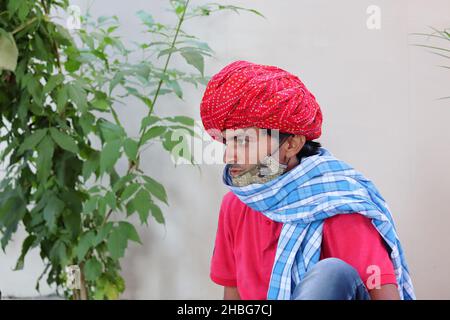 Pali Rajasthan, Indien - 23. Oktober 2021.Rajasthani junger Erwachsener Mann trägt traditionellen roten Turban und Maske Stockfoto