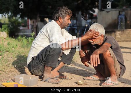 Pali Rajasthan, Indien - 1. November 2021. Nahaufnahme eines indischen Barbiers schneidet einem Mann in einem offenen Hof ohne Laden die Haare Stockfoto