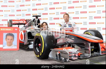 Der Formel 1-Star Jenson Button wird von der TV-Persönlichkeit Myleene Klass begleitet, um bei der British Medical Association in London für Fotos mit einem McClaren-Auto zu posieren und den Sponsor des Automobilherstellers Santander zu bewerben. Stockfoto