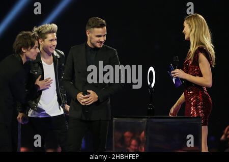 (Von links nach rechts) Louis Tomlinson, Niall Horan und Liam Payne nehmen die Auszeichnung für globalen Erfolg von Rosie Huntington-Whiteley auf der Bühne während der Brit Awards 2014 in der O2 Arena, London, entgegen. Stockfoto