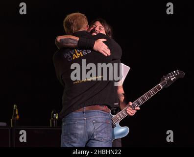 Prinz Harry begrüßt Dave Grohl von den Foo Fighters vor ihrem Auftritt auf der Bühne bei der Abschlussfeier der Invictus Games im Queen Elizabeth Park in East London. Stockfoto