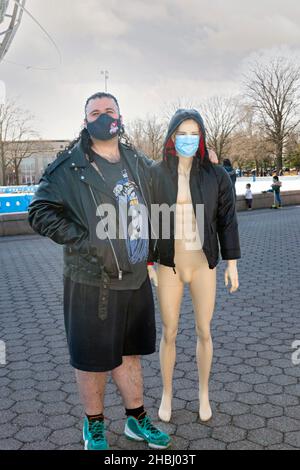 Ein bizarres Foto eines Mannes mit einer männlichen Schaufensterpuppe, die als Frau gekleidet ist. In einem Park in Queens New York City. Stockfoto