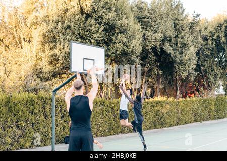 Foto mit Kopierfläche von Freunden, die im Freien Basketball spielen Stockfoto
