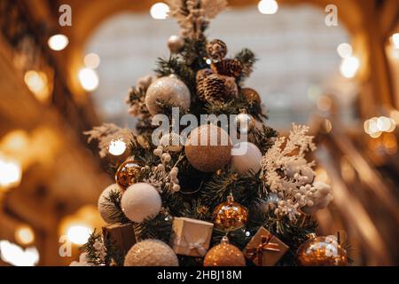 Weihnachtsbaum verziert mit golden glänzenden Geschenkbox und Weihnachtskugeln. Winterfeiertag. Silvester magische festliche Tapete Stockfoto