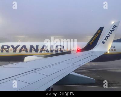 Stansted Airport, Essex, Großbritannien. 6th. Dezember 2021. Ryanair-Flugzeuge werden am Flughafen Stansted geparkt, wenn die Passagiere am frühen Morgen an Bord warten. Stockfoto