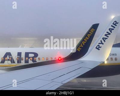 Stansted Airport, Essex, Großbritannien. 6th. Dezember 2021. Ryanair-Flugzeuge werden am Flughafen Stansted geparkt, wenn die Passagiere am frühen Morgen an Bord warten. Stockfoto